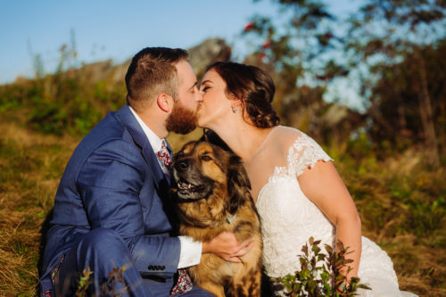 Bride and Groom kiss with dog in the middle 