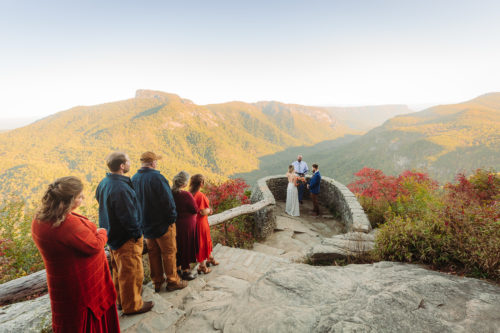 Family looks on as couple marries in the mountains 