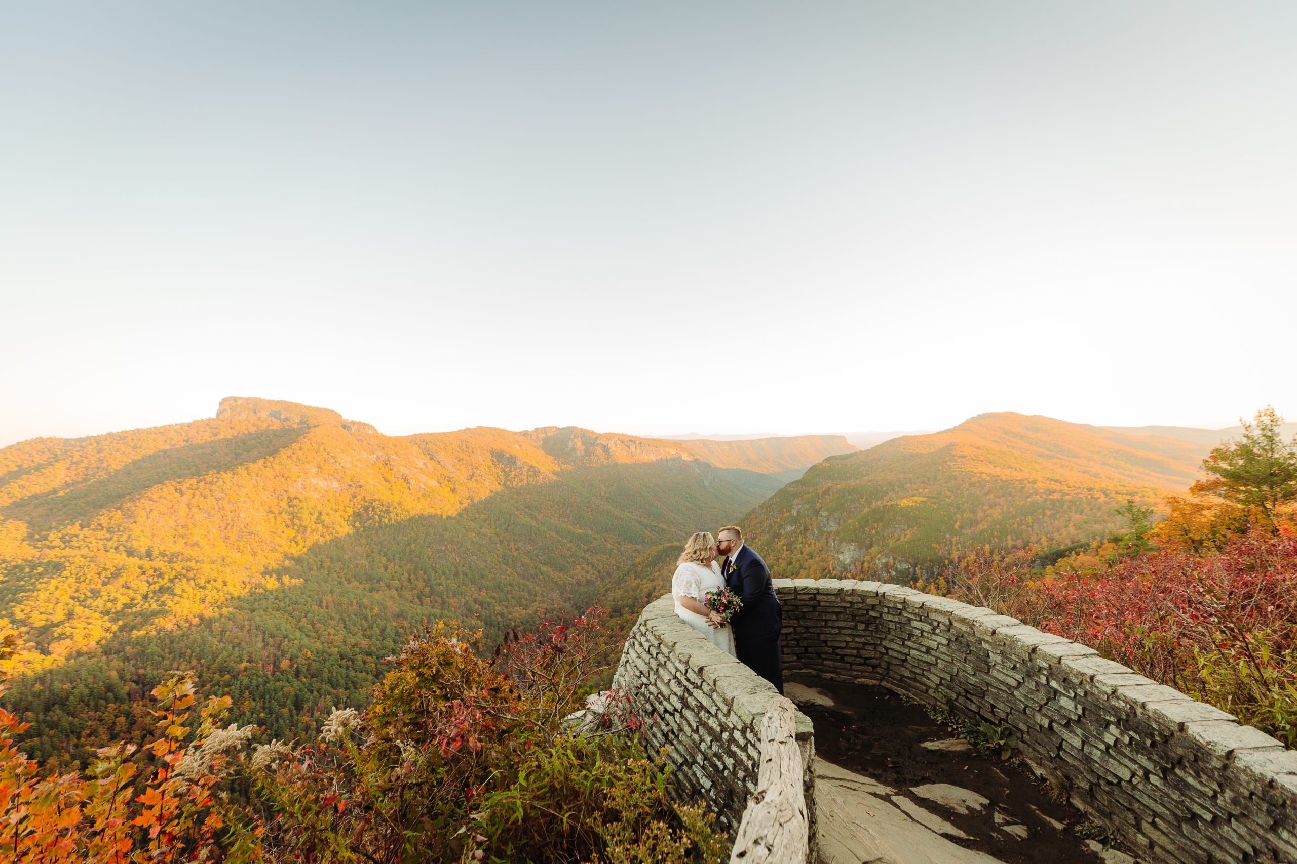 Couple kisses in front of mountain ridges ~ Elope Outdoors