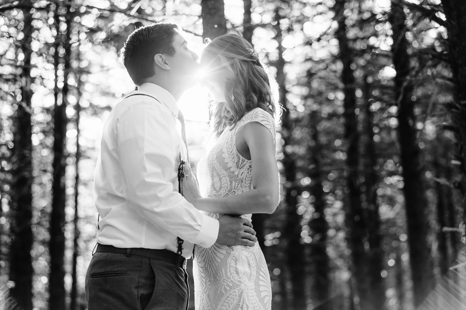Couple kisses in wood BW Elope Outdoors