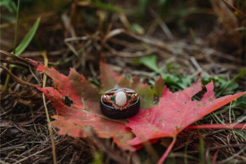 Wedding rings sitting on red leaf during fall in North Carolina.