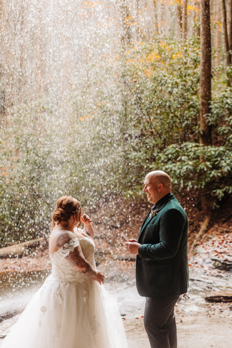 Bride and groom exchange vows in front of waterfall during North Carolina elopement.