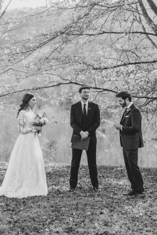 a black and white photo of an outdoor wedding ceremony in asheville during winter