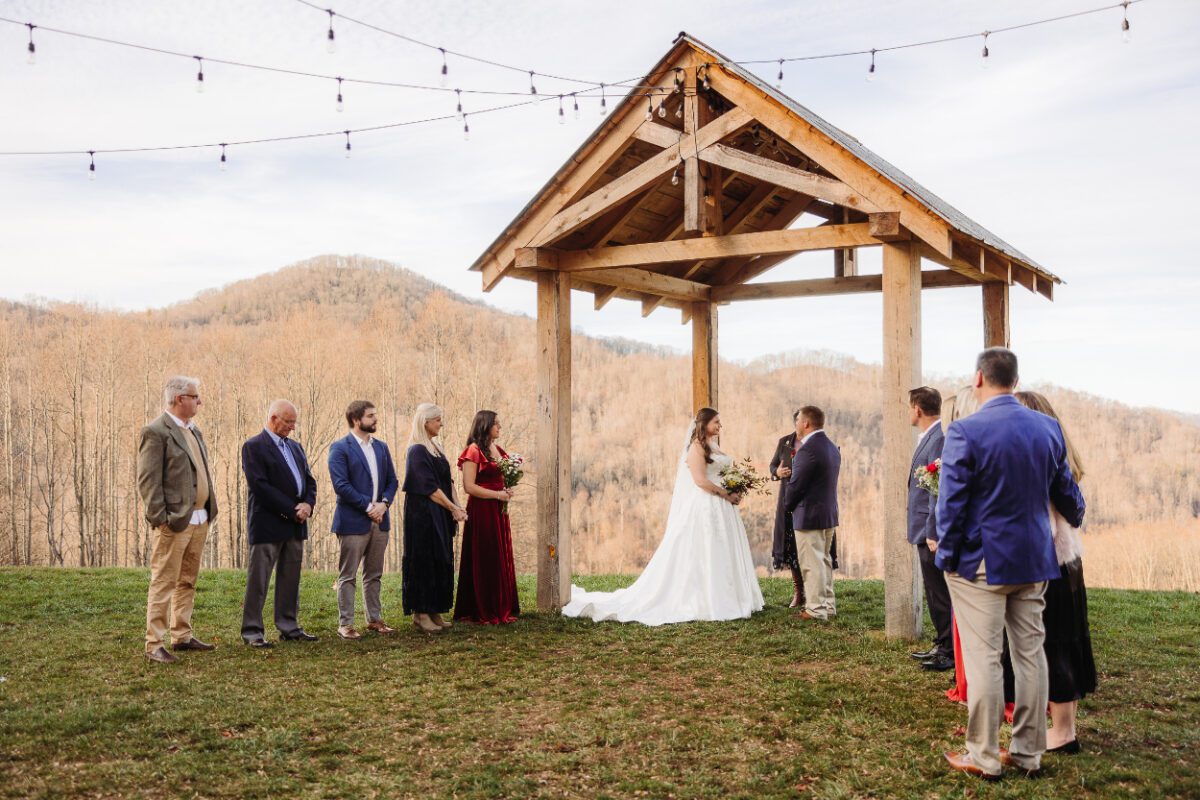 outdoor micro-wedding ceremony with a wood structure as the backdrop