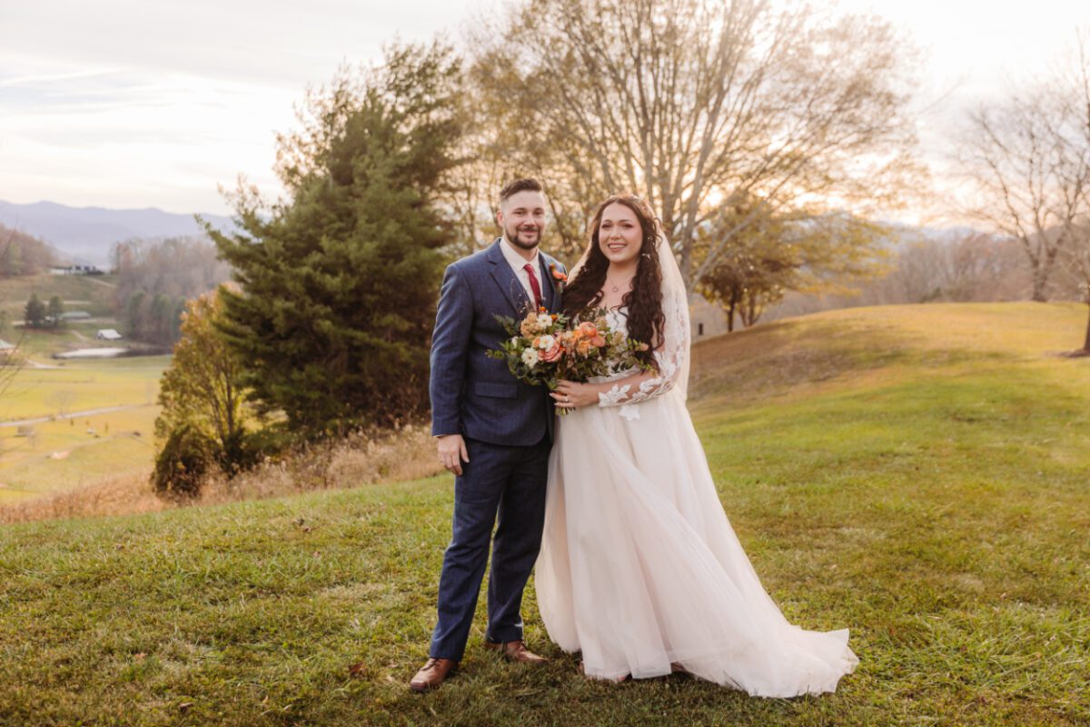 golden hour photo of a bride and groom outside with trees in the background