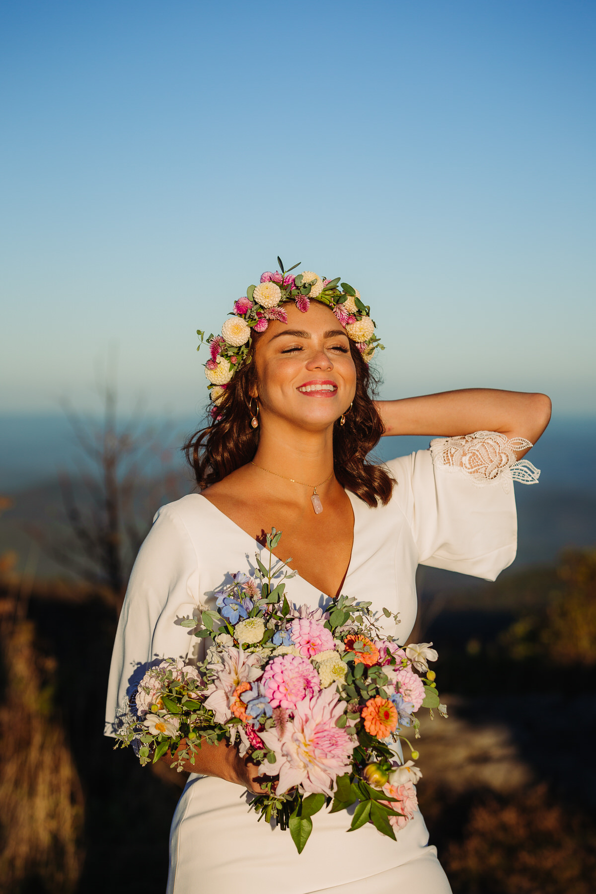 Joyful bride embracing the beauty of her outdoor elopement, radiating freedom and happiness as she explores nature in her flowing gown, surrounded by breathtaking mountain view