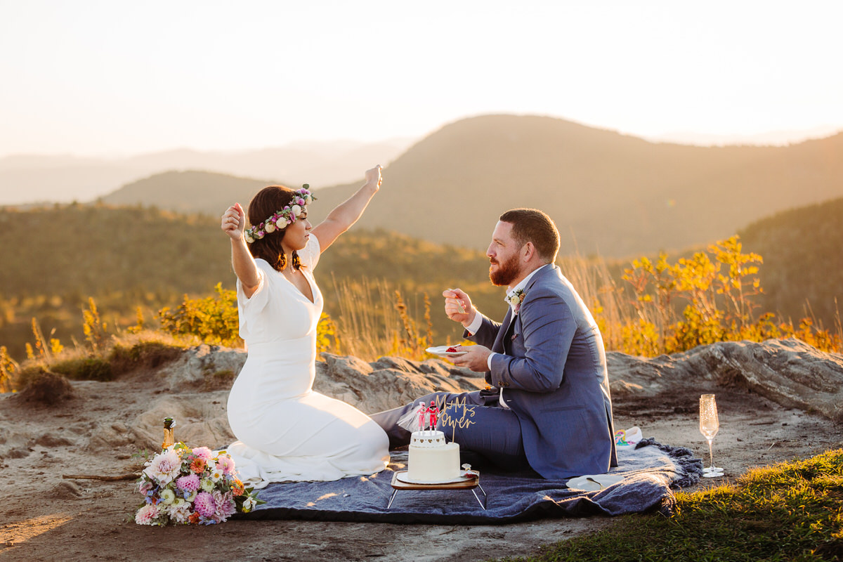 Carefree bride enjoying her intimate outdoor elopement with nature, radiating joy and freedom in a stunning mountain setting, with flowing dress and natural surroundings