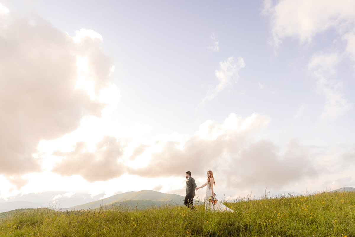 Just married couple hiking hand in hand along a scenic Blue Ridge Mountain trail.