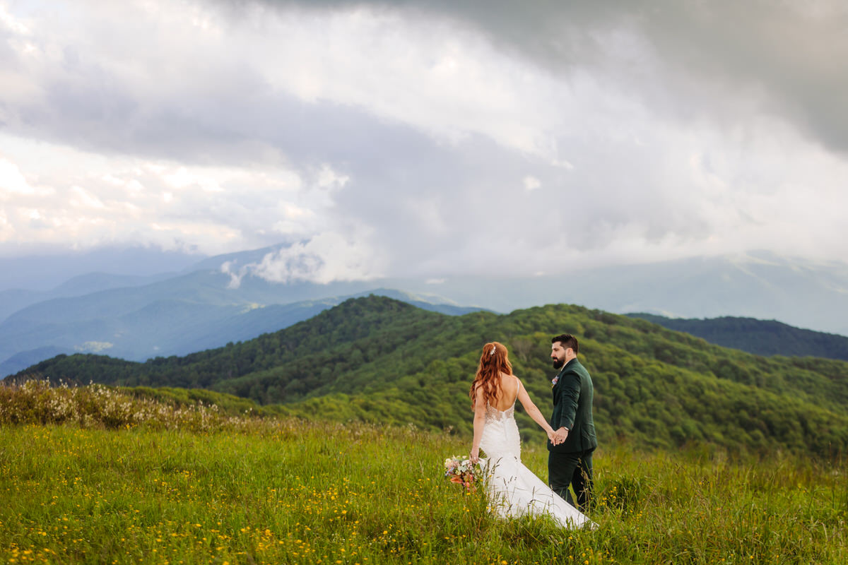 Romantic elopement couple embracing on a mountaintop at sunset in the Blue Ridge Mountains.