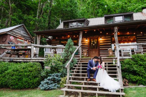 couple cuddling in front of Asheville cabin 