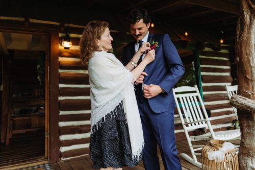 Mother pinning boutonniere on groom