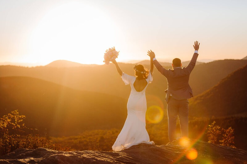 Couple celebrating on mountain at golden hour during their Asheville elopement with a sunset ceremony.