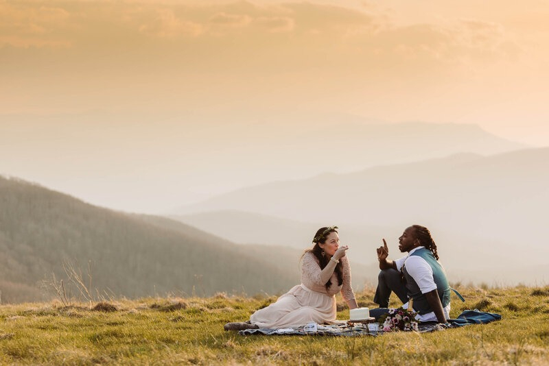 Couple shares mountaintop picnic during their sunset ceremony elopement in the Blue Ridge Mountains.