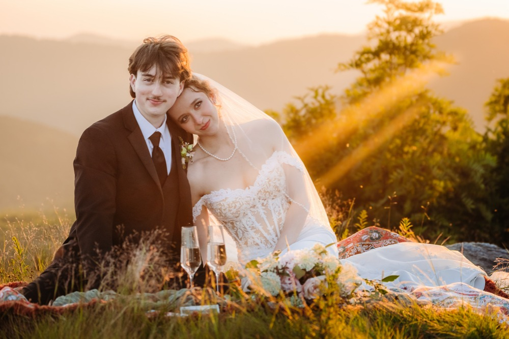 Newlyweds share a romantic moment at their Asheville mountaintop sunset ceremony elopement picnic.