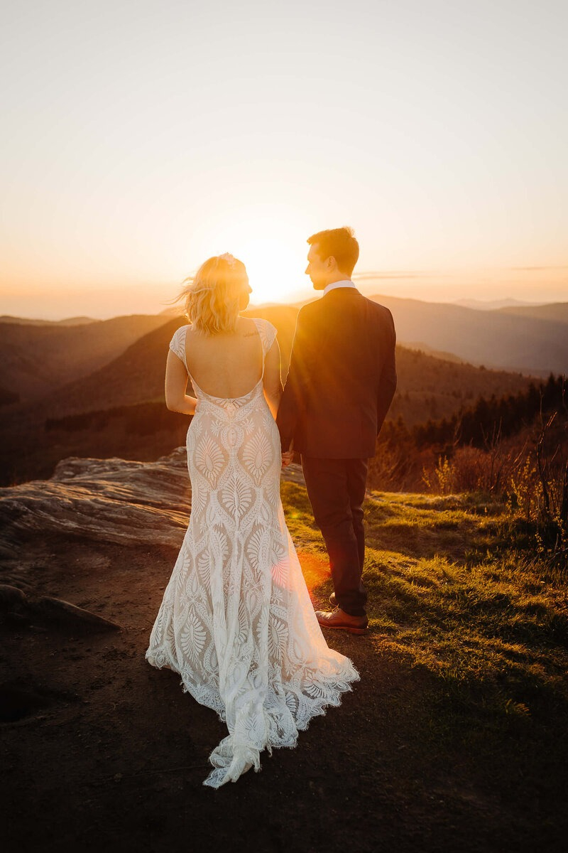 Bride and groom holding hands during their mountain sunset ceremony at an Asheville elopement.