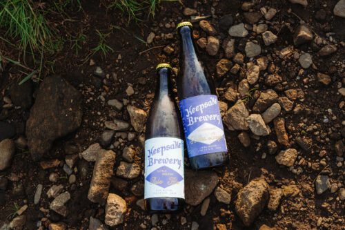 Craft beer bottles from Keepsake Brewery on rocky ground show how to incorporate personal touches into your elopement.