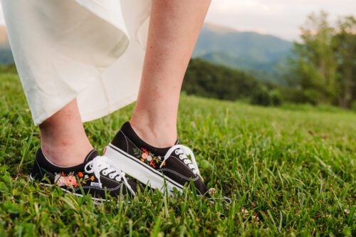 Bride in embroidered sneakers under wedding dress shows how to incorporate personal touches into your elopement.