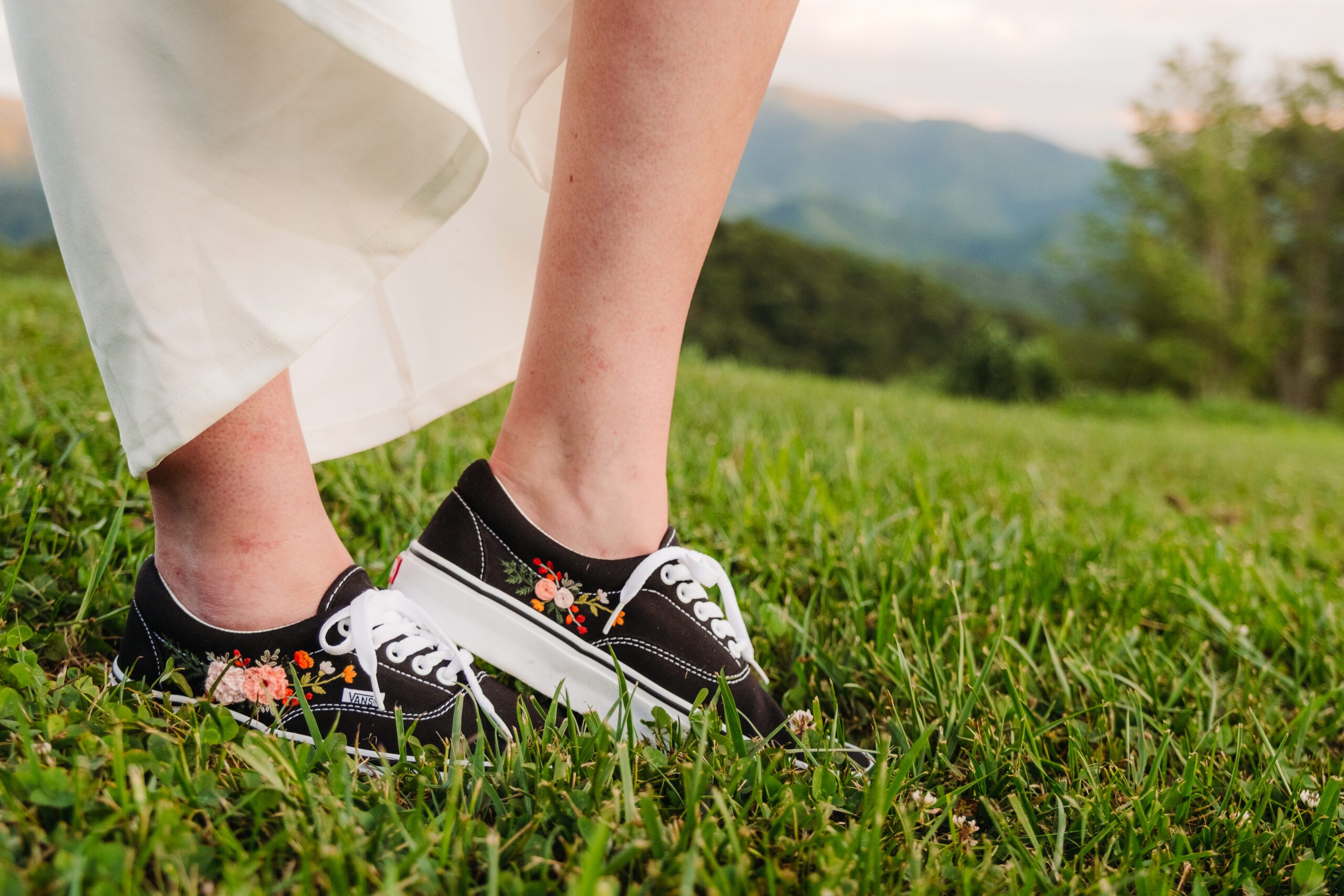 Bride in embroidered sneakers under wedding dress shows how to incorporate personal touches into your elopement.