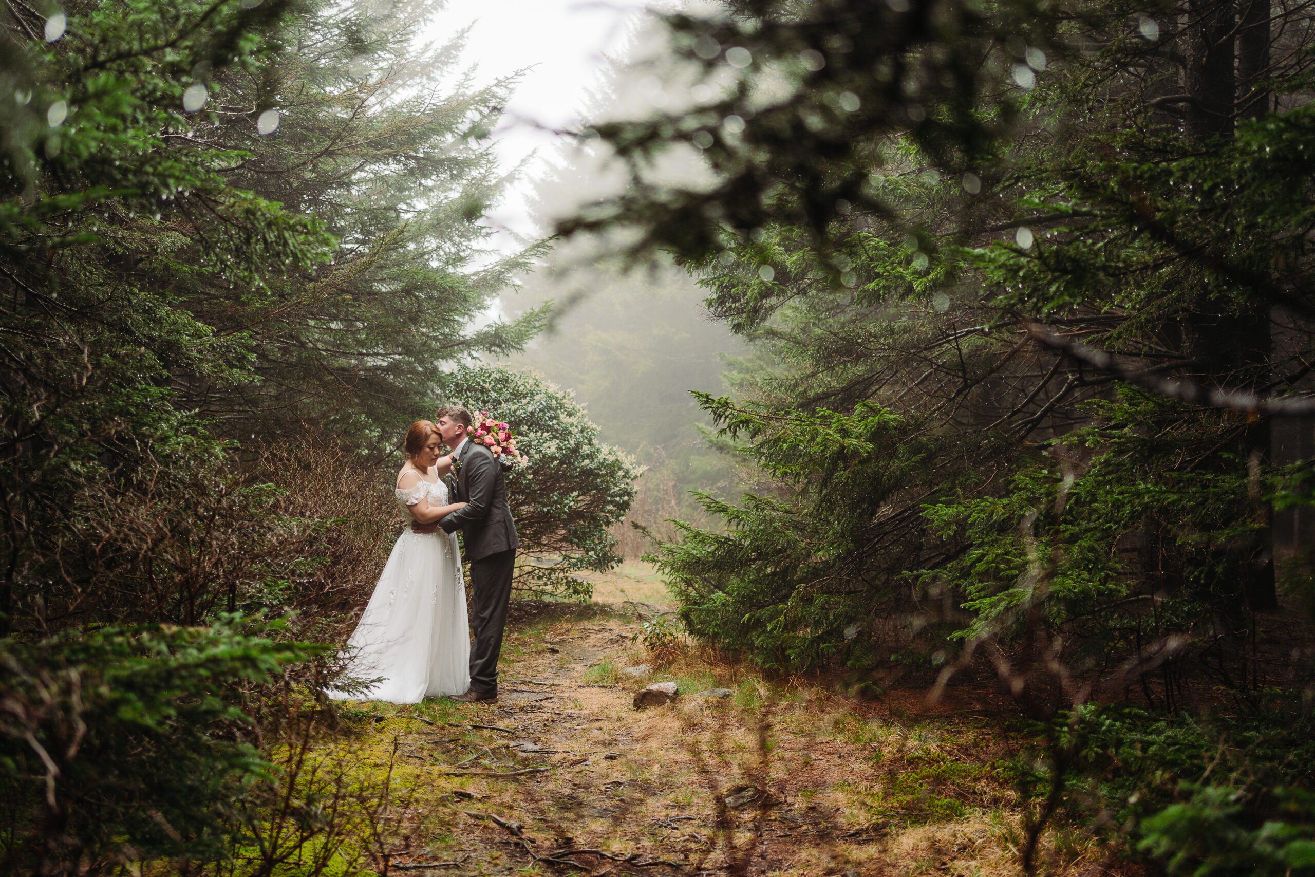 places to elope in asheville, a husband and wife hold each other close in a foggy forest 