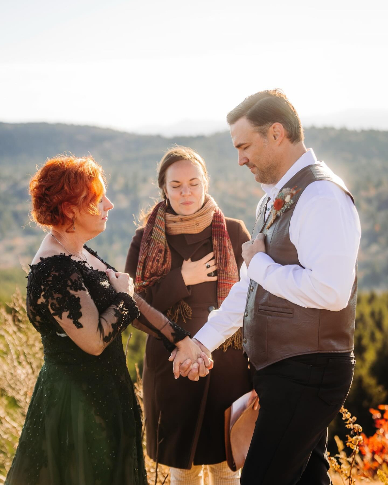 Couple renews vows during a heartfelt outdoor ceremony in Asheville, holding hands at sunset.