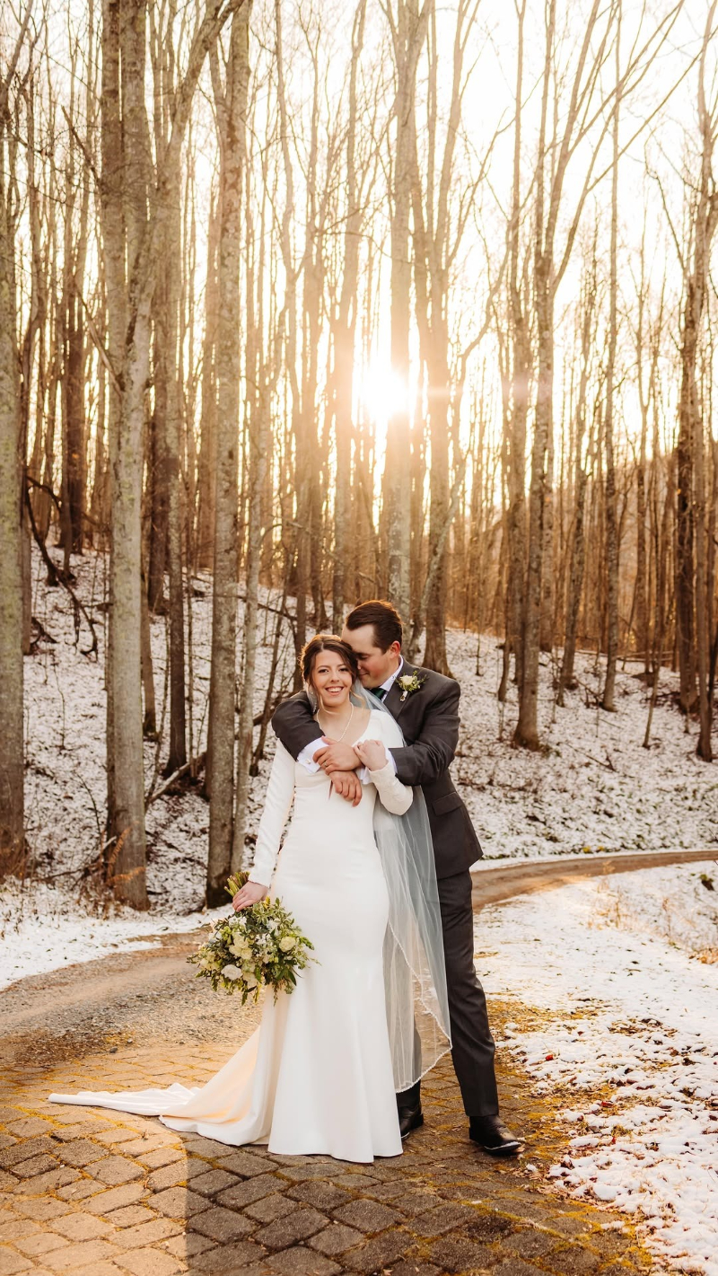Smiling couple in winter forest setting during their secret forest elopement near Asheville, surrounded by snow-dusted trees.