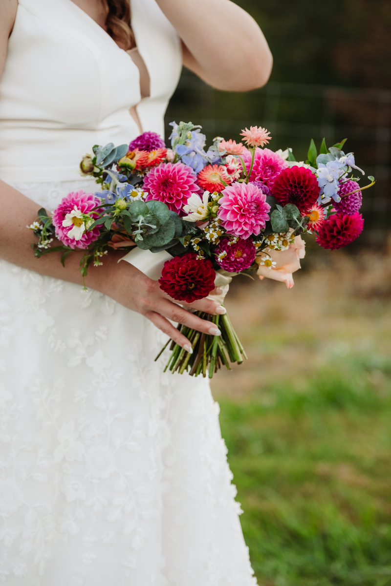 Bride holding a bright wildflower bouquet during her outdoor elopement and honeymoon combo in Asheville.