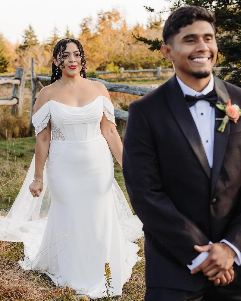 Bride approaches groom during first look moment in a mountain field as part of elopement planning.