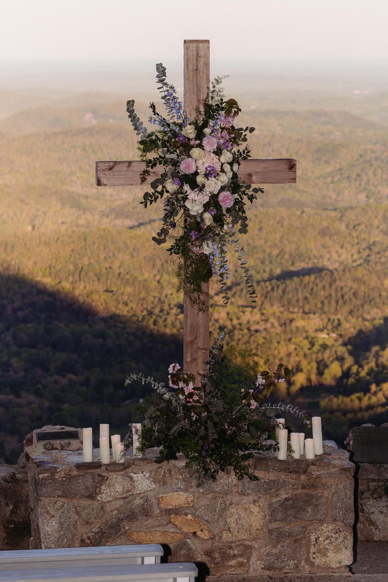 Floral cross overlooking mountains at Blue Ridge Mountain wedding venues ceremony site.