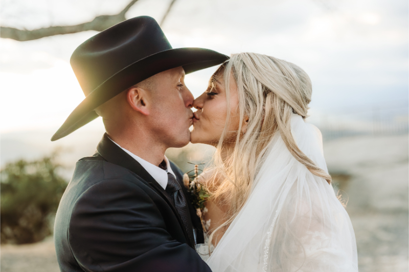 Bride and groom sharing a sunset kiss during intimate mountain elopement.