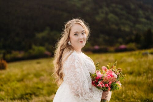 Bride holding a lush bouquet with June wildflowers in North Carolina mountains