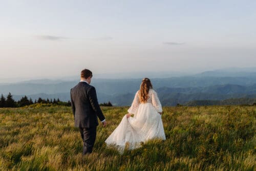 Couple eloping on a mountaintop in Asheville surrounded by vibrant summer greenery