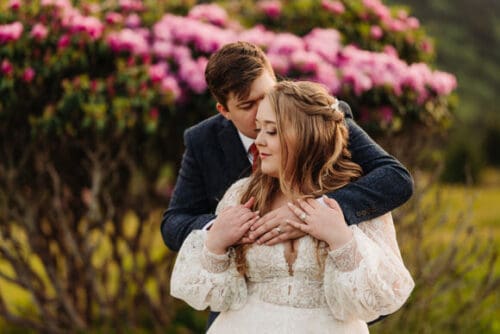 ntimate embrace surrounded by rhododendrons during a North Carolina mountain elopement