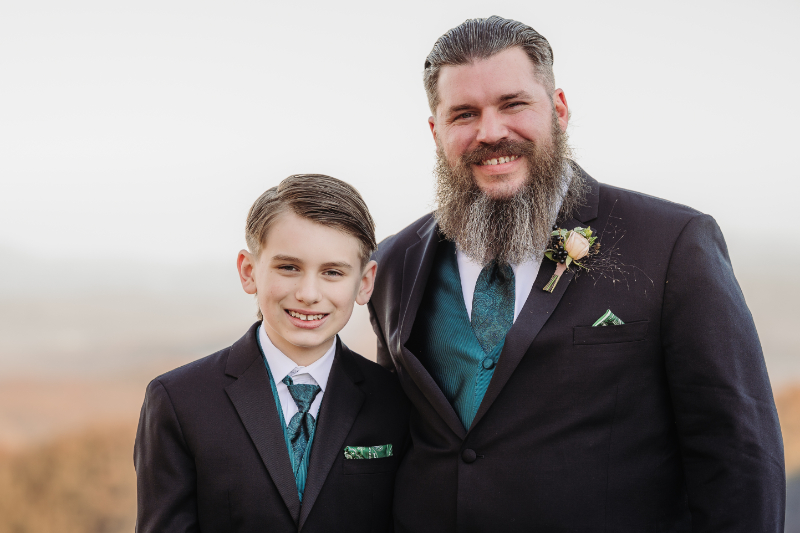 Groom and young boy smiling together during a family moment at an elopement in Asheville NC.