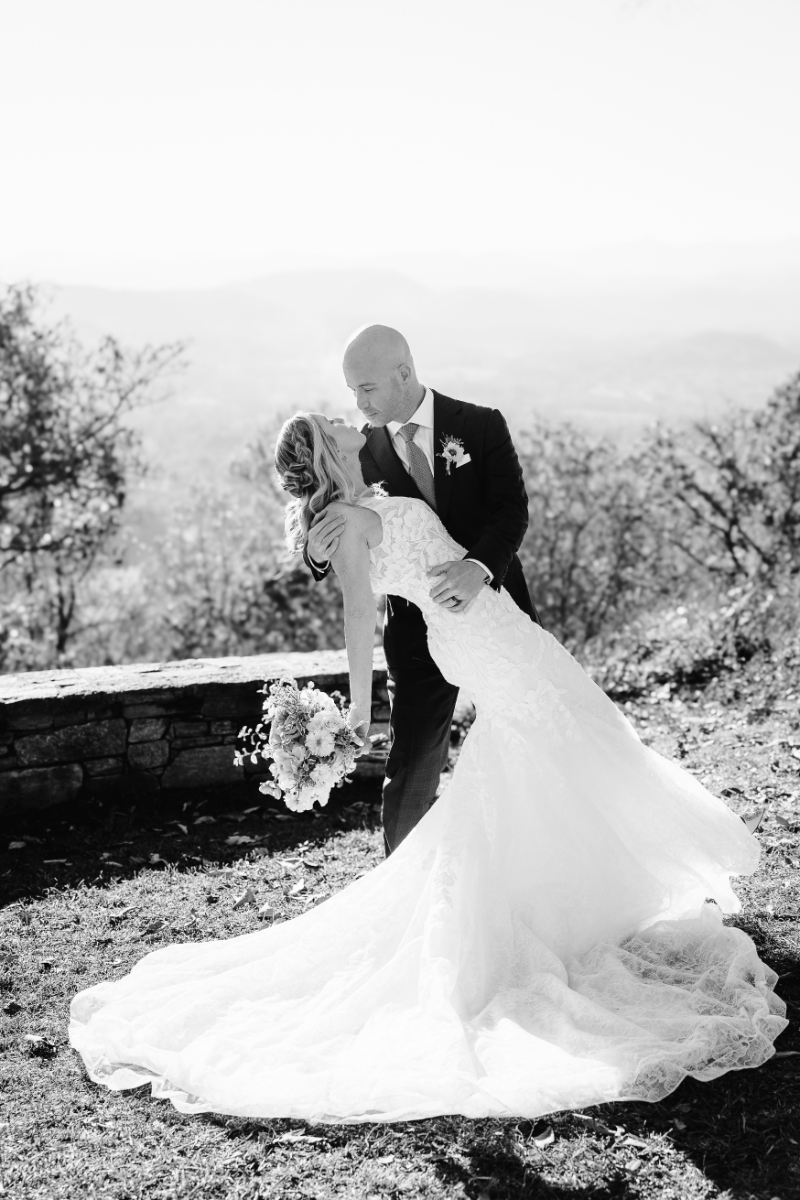Elopement planning couple in black and white, romantic dip pose with flowing dress outdoors