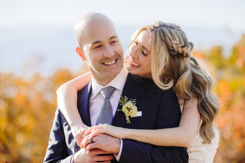Elopement planning couple embracing at sunset in mountains, joyful and intimate outdoor wedding moment
