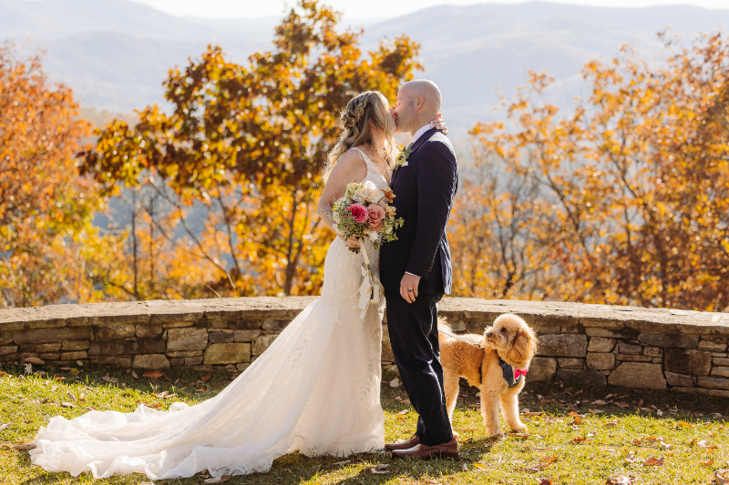 Elopement planning couple standing in fall mountains with dog, romantic outdoor ceremony moment