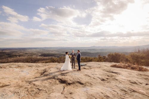 Small Asheville NC elopement ceremony on a mountain overlook with officiant and couple