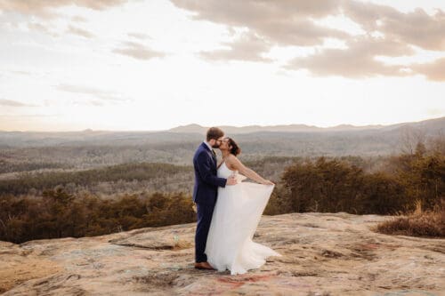 Bride and groom kissing on a mountain overlook during Asheville elopement