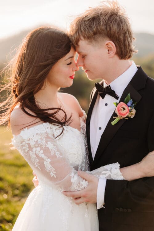 Bride and groom embracing at sunset with foreheads touching during intimate Blue Ridge Mountain elopement