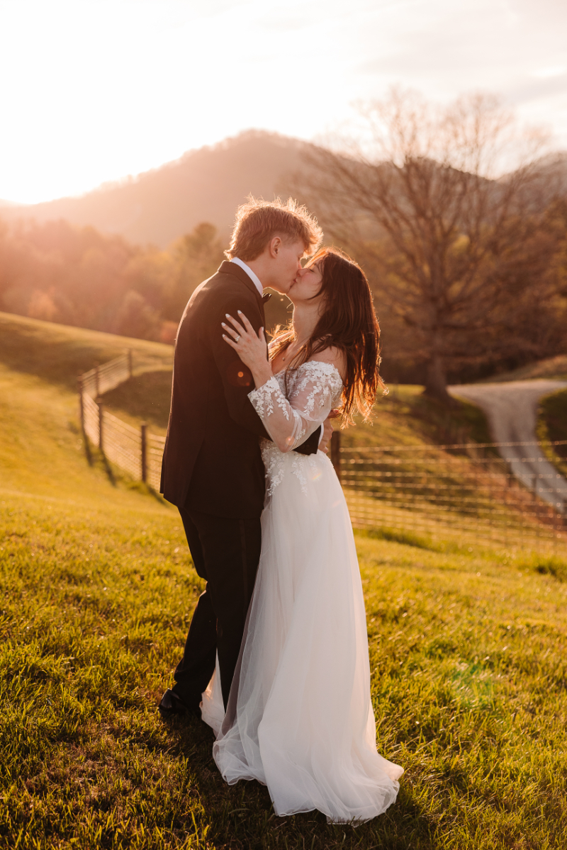 Couple shares a sunset kiss in golden light, a romantic moment from their adventure elopement package