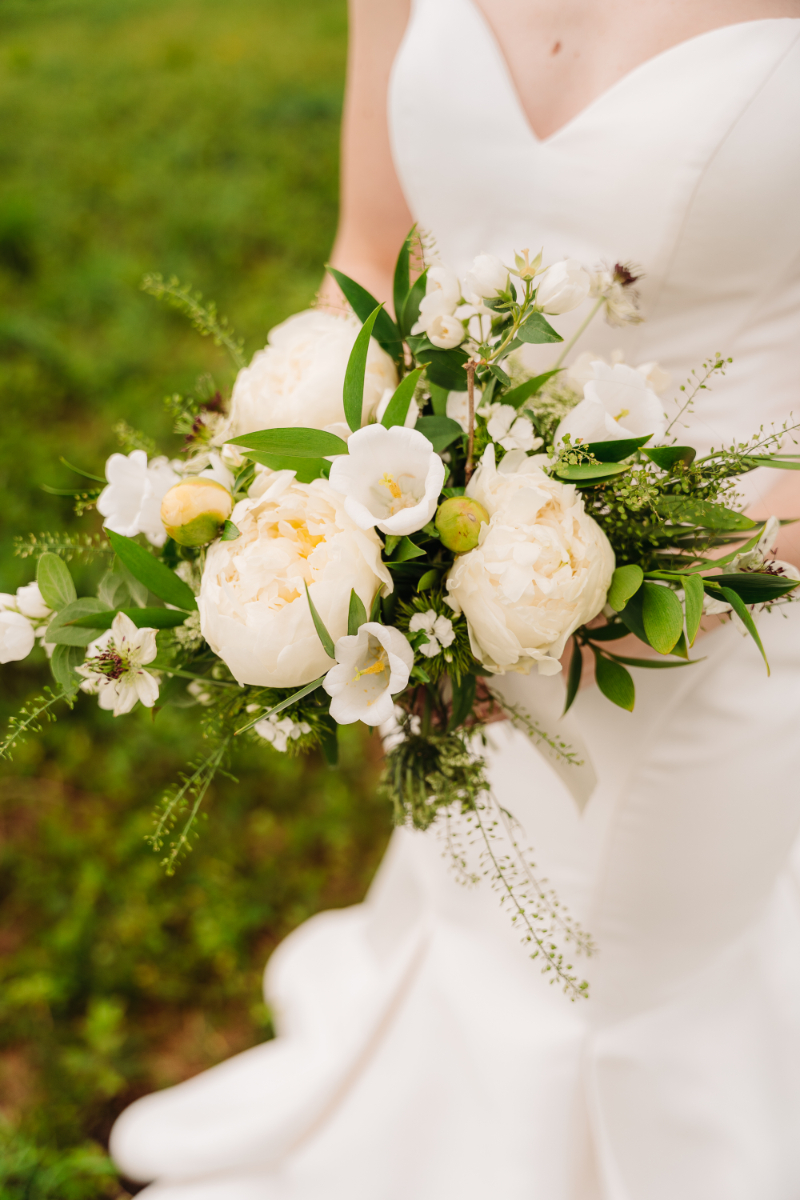 Bridal bouquet with white flowers during a remote elopement in the Blue Ridge Mountains surrounded by natural greenery.