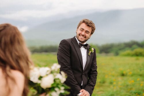 Groom smiling during a remote elopement ceremony in the Blue Ridge Mountains surrounded by peaceful outdoor scenery.