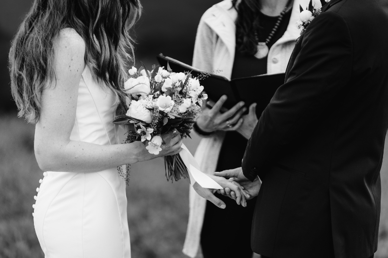 Couple exchanging vows during a remote elopement ceremony in the Blue Ridge Mountains with bouquet and officiant.