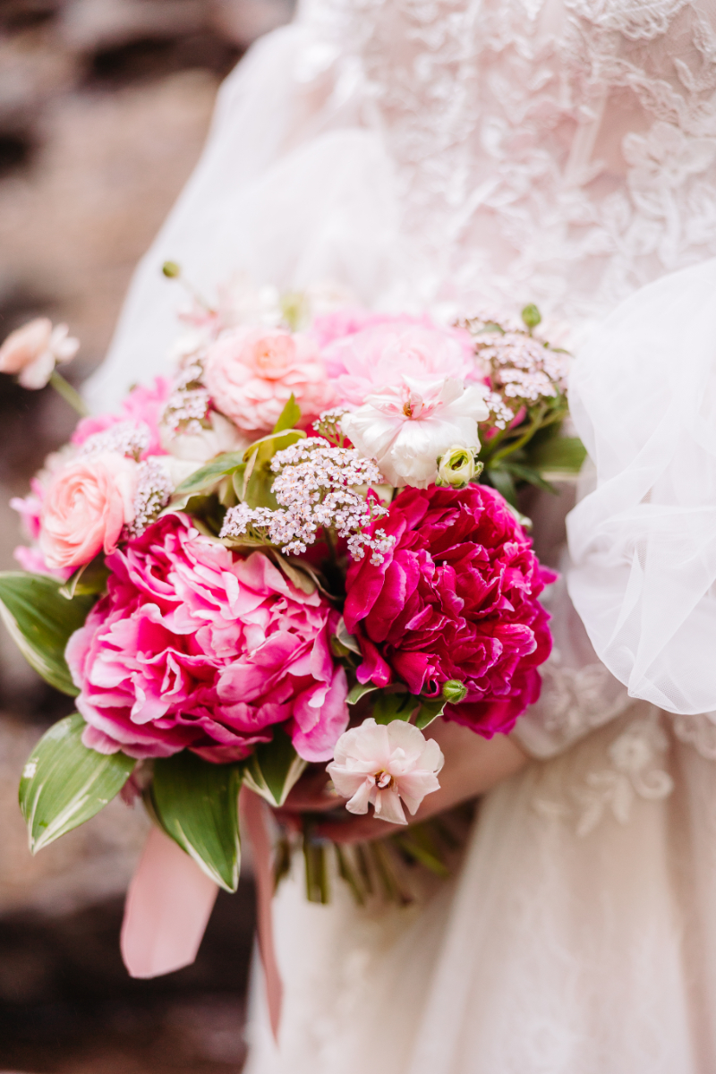 Close up of bright pink wedding bouquet with fresh flowers during an intimate outdoor elopement