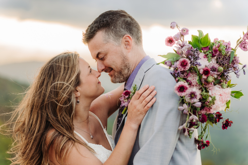 Close up portrait of a couple embracing during an intimate outdoor wedding with soft natural light