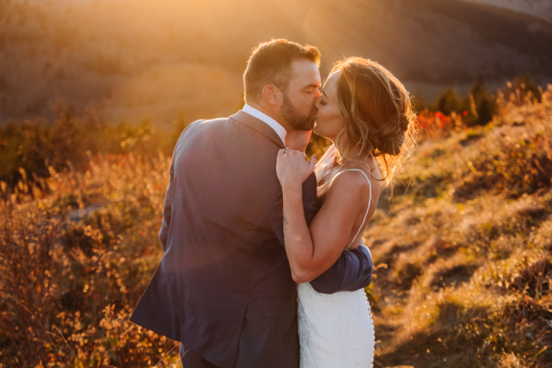 Couple sharing a quiet moment at sunset amid Blue Ridge Mountains fall colors during elopement.