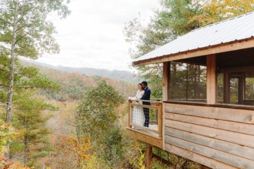 Couple embracing on the deck of a mountain cabin near Hot Springs NC, a perfect Airbnb for an intimate elopement weekend.