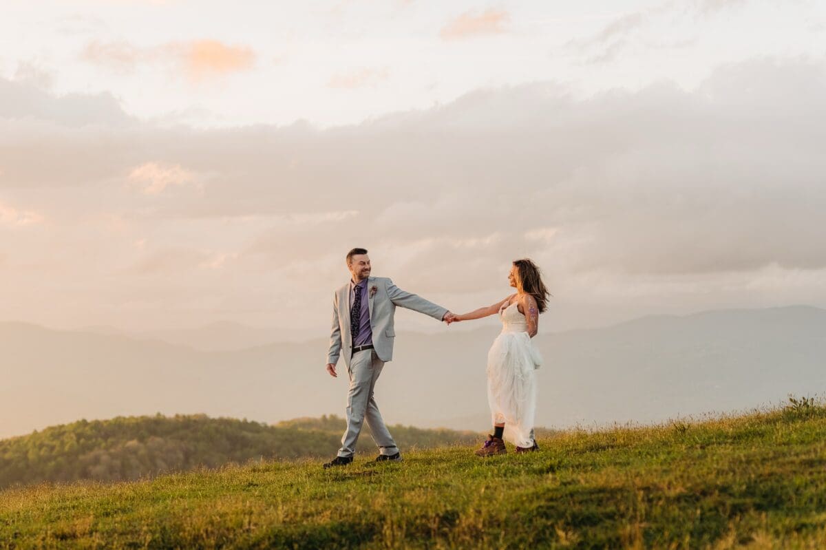 Natalie and Charles hold hands during golden hour at their Bearwallow Mountain elopement near Asheville, North Carolina.