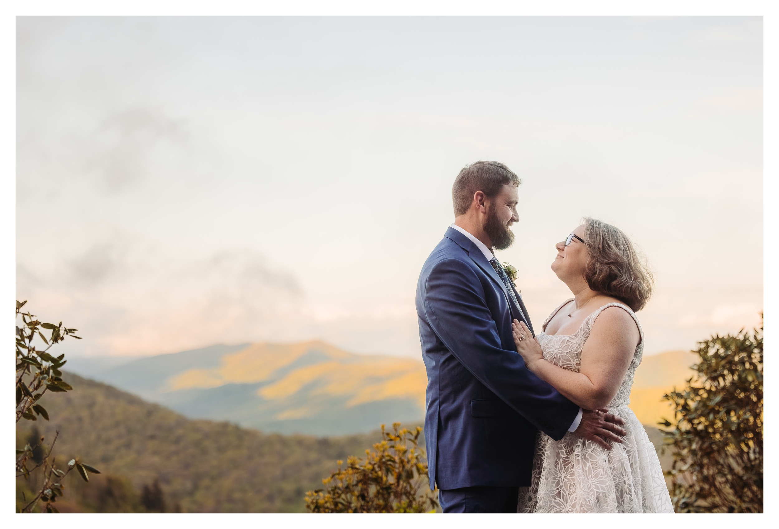 Bride and groom embracing at a scenic Blue Ridge Mountain overlook during their elopement.