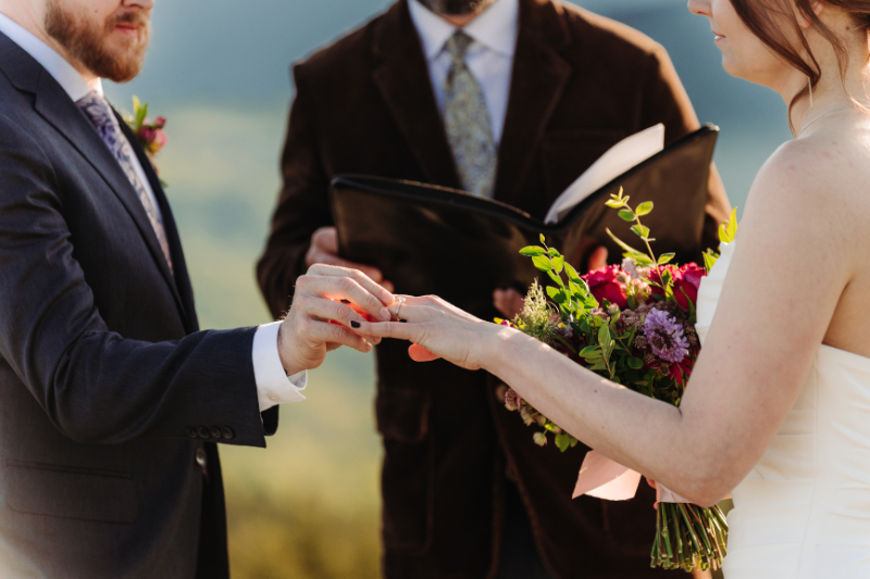 Couple exchanging rings during an elopement in North Carolina with mountain views in the background.